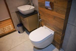 a bathroom with a white toilet and a sink at La Paraiso by WhiteTrip in Vagamon