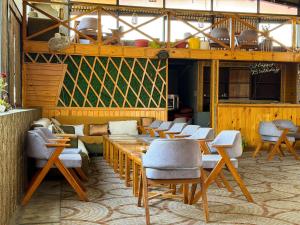 a restaurant with tables and chairs in a room at AARYA Corbett Resort & SPA - 8 minutes drive to Kosi River in Nainital