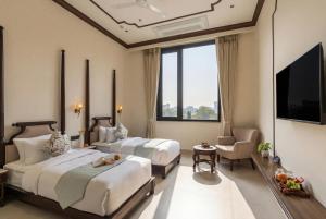 a hotel room with two beds and a television at Luxuria Varanasi By Moustache in Varanasi +69 photos