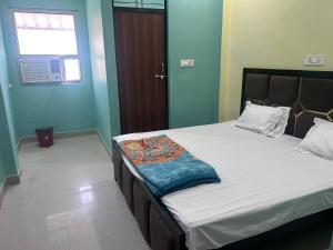 a bedroom with a bed with white sheets and blue walls at Virasat Guest House in Lucknow