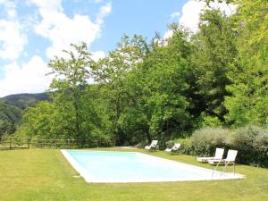 una piscina en un patio con 2 sillas en Belvilla by OYO Le Olive, en Vaglia