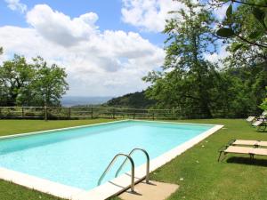 een zwembad met een tafel en een bank ernaast bij Belvilla by OYO Le Olive in Vaglia