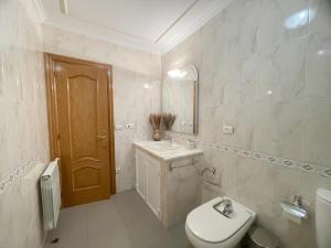 a bathroom with a toilet and a sink and a mirror at A DE NENO in Melide