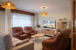 a living room with leather furniture and a tv at A DE NENO in Melide