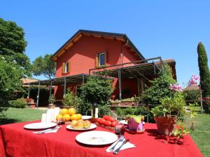 una mesa con un mantel rojo con fruta. en Peaceful Farmhouse in Rome with Pool, en Monterotondo