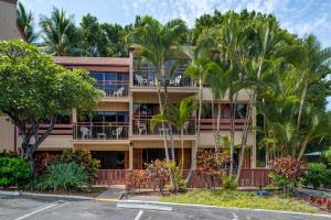 un edificio de apartamentos con palmeras delante en The Kona Billfisher en Kailua-Kona