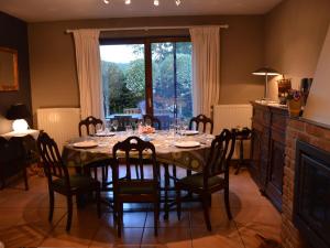 a dining room with a table and chairs and a window at Modern Holiday Home in Stavelot with Fireplace in Stavelot