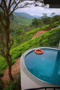 a swimming pool with a red tube in a hill at La Paraiso by WhiteTrip in Vagamon +46 photos