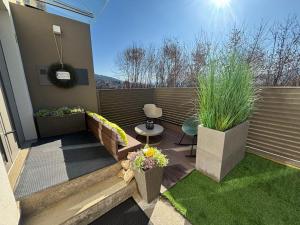 a small patio with two potted plants and a table at Apartment Wörtherseeliebe in Pörtschach am Wörthersee