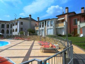 a resort with a pool and chairs and buildings at Sakura House By Bookinggardalake in Moniga