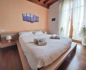 a bedroom with a large bed with towels on it at Sakura House By Bookinggardalake in Moniga +28 photos