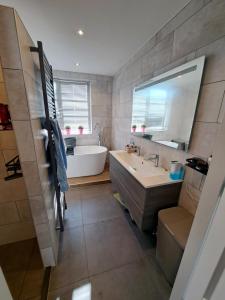 a bathroom with a tub and a sink and a mirror at Villa shared Fieldsight Doornspijk - a shared villa no breakfast in Doornspijk +61 photos