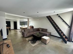 a living room with a couch and a staircase at Logis Hotel du Maine in Laval