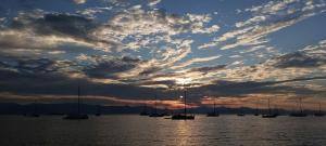 a group of boats in the water under a cloudy sky at Kamari Guest House Corfu in Corfu International Airport I Kapodistrias