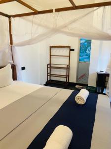 a bedroom with a bed with two towels on it at Ocean Breeze in Dickwella