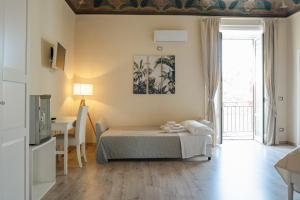 a bedroom with a bed and a table and a window at B&B Matteo Bonello - Fianco Cattedrale in Palermo