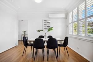 a dining room with a table and chairs at Fairlight Luxe Escape 4BR with Parking in Killara