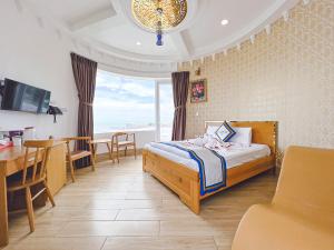 a bedroom with a bed and a dining room with a table at Phong Dung Beach Hotel Phan Ri Cua in Tuy Phong