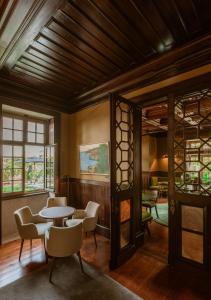 a dining room with tables and chairs and windows at Palacete Severo in Porto