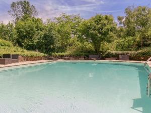 a large swimming pool with chairs and trees at Holiday home in Aquitaine with private garden in Meyrals