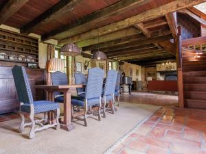 a dining room with a table and blue chairs at Holiday home in Aquitaine with private garden in Meyrals