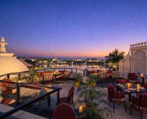 a patio with tables and chairs on top of a building at Swaroop Vilas - Lake Facing Boutique Hotel in Udaipur
