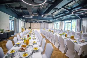 a long banquet hall with white tables and white chairs at Eco Nieborów in Nieborów