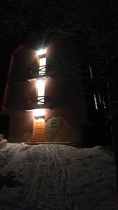 a house with a light on the side of it at night at Apartments Aurelius in Jahorina