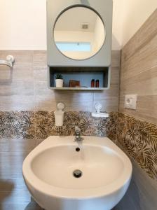 a bathroom with a sink and a mirror at Ortigia Mastrarua rooms in Syracuse +48 photos