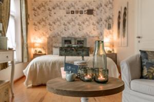 a living room with a bed and a table with candles at Bed & Boterham Carpediem in Hamont +6 photos