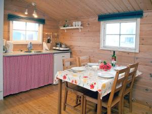 a kitchen with a table with chairs and a tablecloth on it at Hundested Havnehytter in Hundested