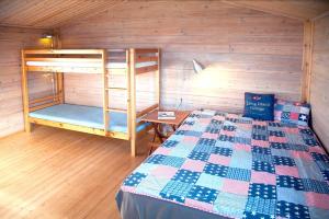 a bedroom with a bed and bunk beds in a room at Hundested Havnehytter in Hundested