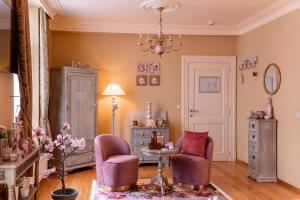 a living room with two chairs and a table at Bed & Boterham Carpediem in Hamont