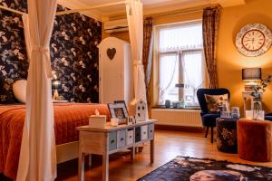 a bedroom with a bed and a table and a window at Bed & Boterham Carpediem in Hamont