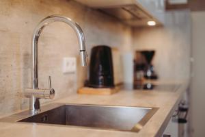 a kitchen sink with a faucet on a counter at Ferienwohnungen Gut Mischenried in Weßling +144 photos
