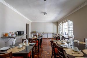 a dining room with tables and chairs and a window at Ulifalodge whitehouse in Hillcrest
