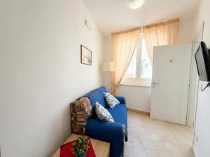 a living room with a blue couch and a window at Ortigia Mastrarua rooms in Syracuse