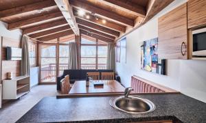 a kitchen and living room with a sink and a table at Grafenberg Resort by Alpeffect Hotels in Wagrain