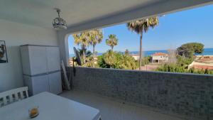 a kitchen with a large window with a view of the ocean at Apartamentos Cap y Corp in Alcossebre