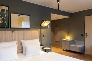 a bedroom with a bed and a desk and a lamp at Scandic Stuttgart Europaviertel in Stuttgart