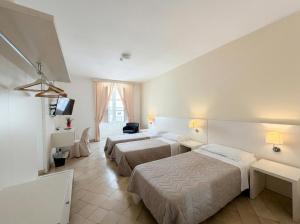 a hotel room with two beds and a television at Ortigia Mastrarua rooms in Syracuse