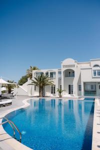 a swimming pool in front of a villa at Santorini Gem in Órmos Athiniós