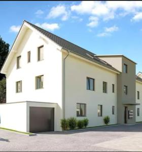 a large white house with a garage at Modern ausgestattete Neubauwohnung in Lottstetten