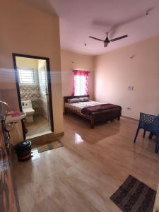 a large room with a bed and a mirror at Kalpatharu Sprit Boarding and Lodging in Sivaganga +6 photos