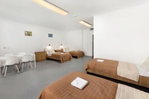 a room with two beds and a table and chairs at Nyíltvízi Edzőközpont in Dunakeszi