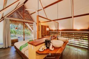 a bathroom with two sinks and a large bed at Hotel Shawandha Costa Rica in Puerto Viejo