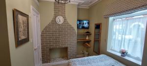 a room with a brick fireplace with a clock on the wall at Salisbury Guest House - free parking in York +29 photos