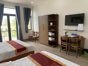 a hotel room with a bed and a desk and a television at THIÊN HÀ Motel in Soc Trang