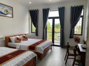 a hotel room with two beds and a window at THIÊN HÀ Motel in Soc Trang