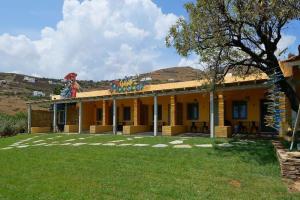 a yellow building with a sign on top of it at Rooster Guesthouse Rooms in Kipri